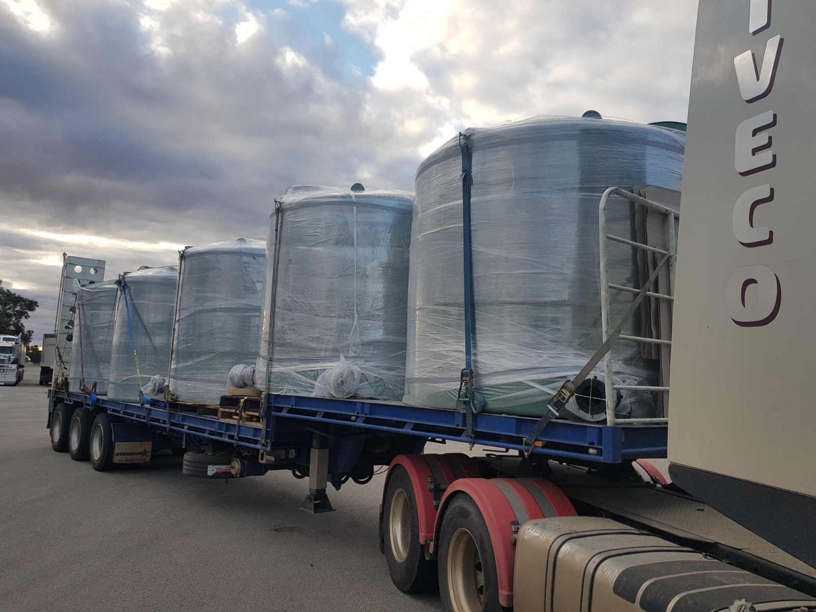 Industrial water storage tanks wrapped and loaded on Iveco flatbed trailer